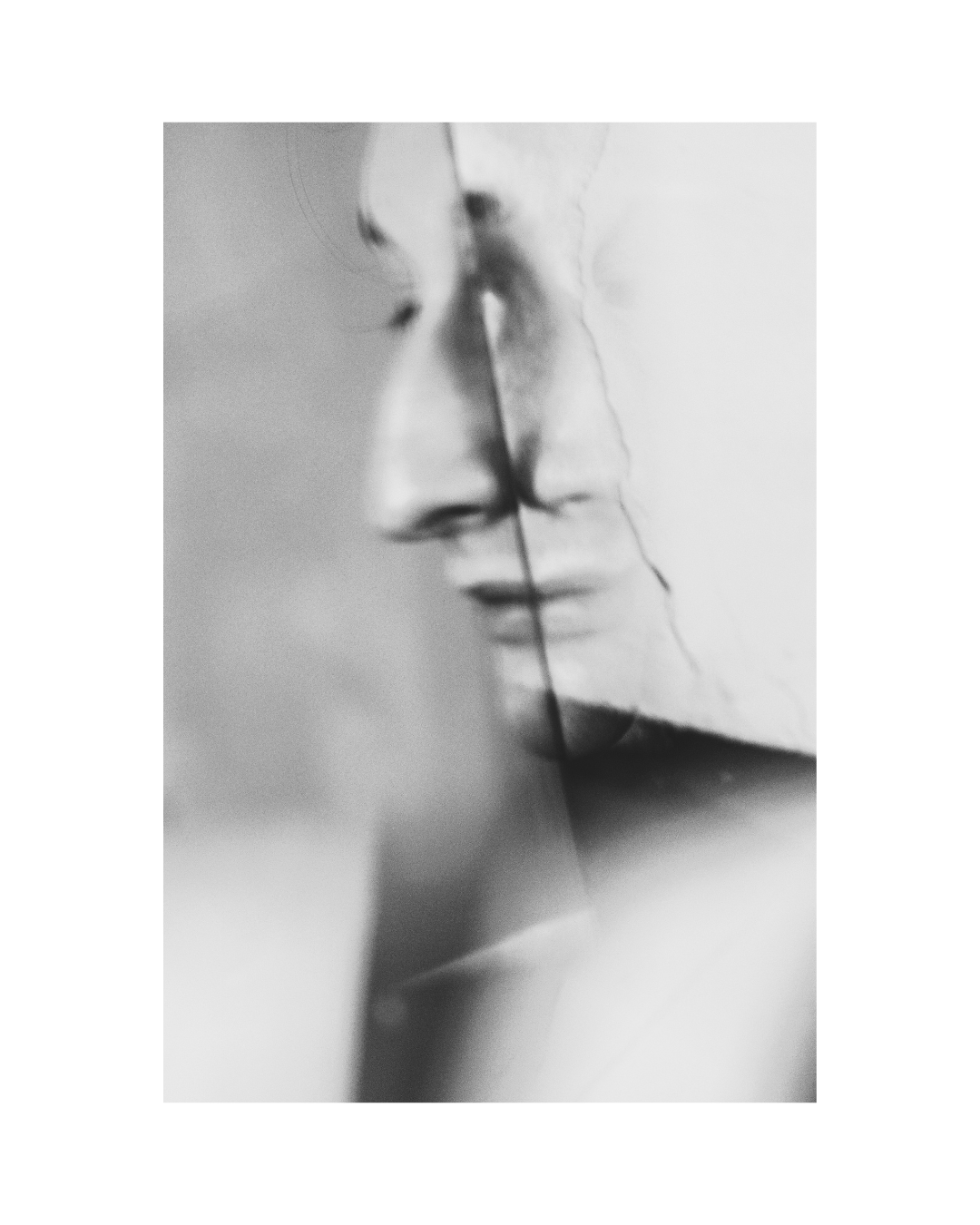 A tightly framed person in contrasting light and shadow, in black and white by Lilit L Hovhanni.
