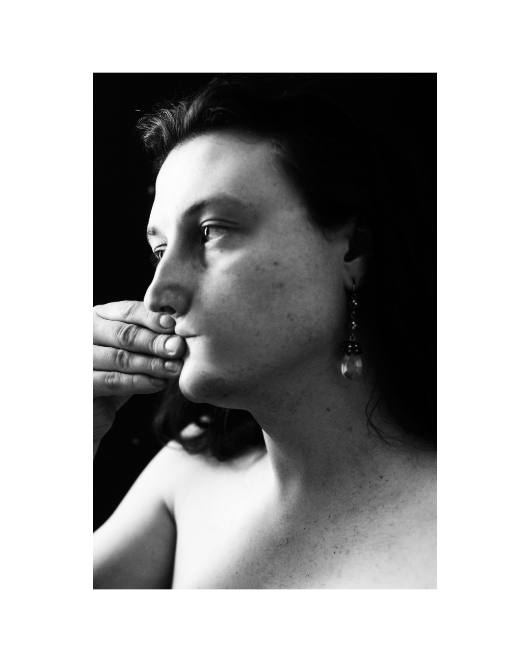 Close view of a person in black and white, with strong contrasts between bright and dark areas.