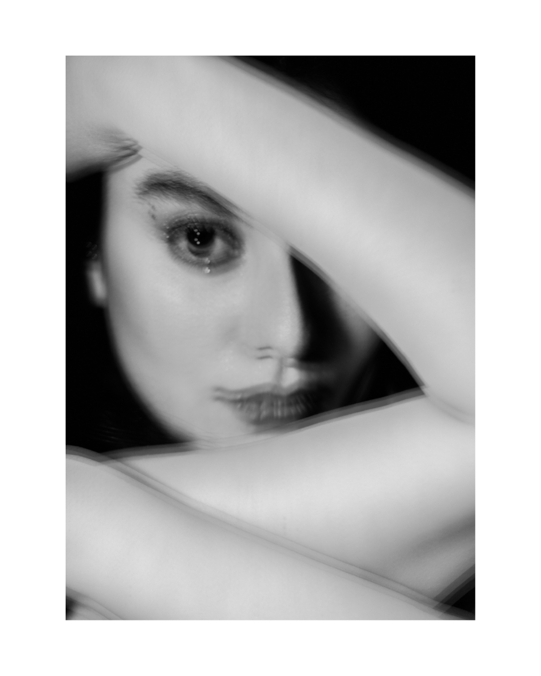 A woman with dark hair looks toward the camera in a tightly cropped vertical portrait.