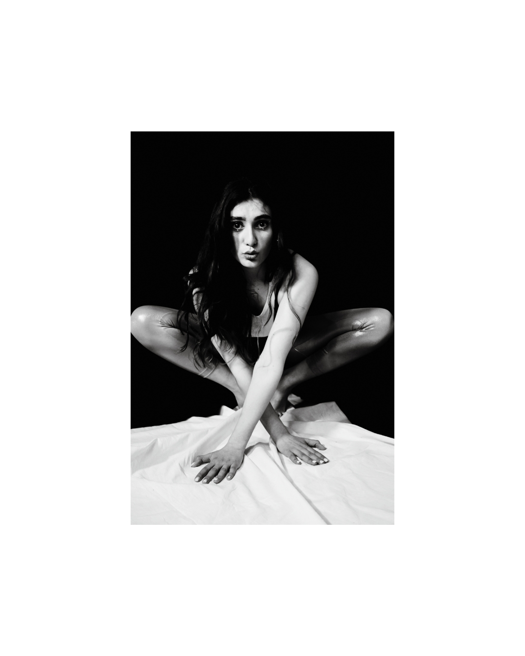 A dark-haired woman faces the camera within a white border, her face and upper body closely framed.