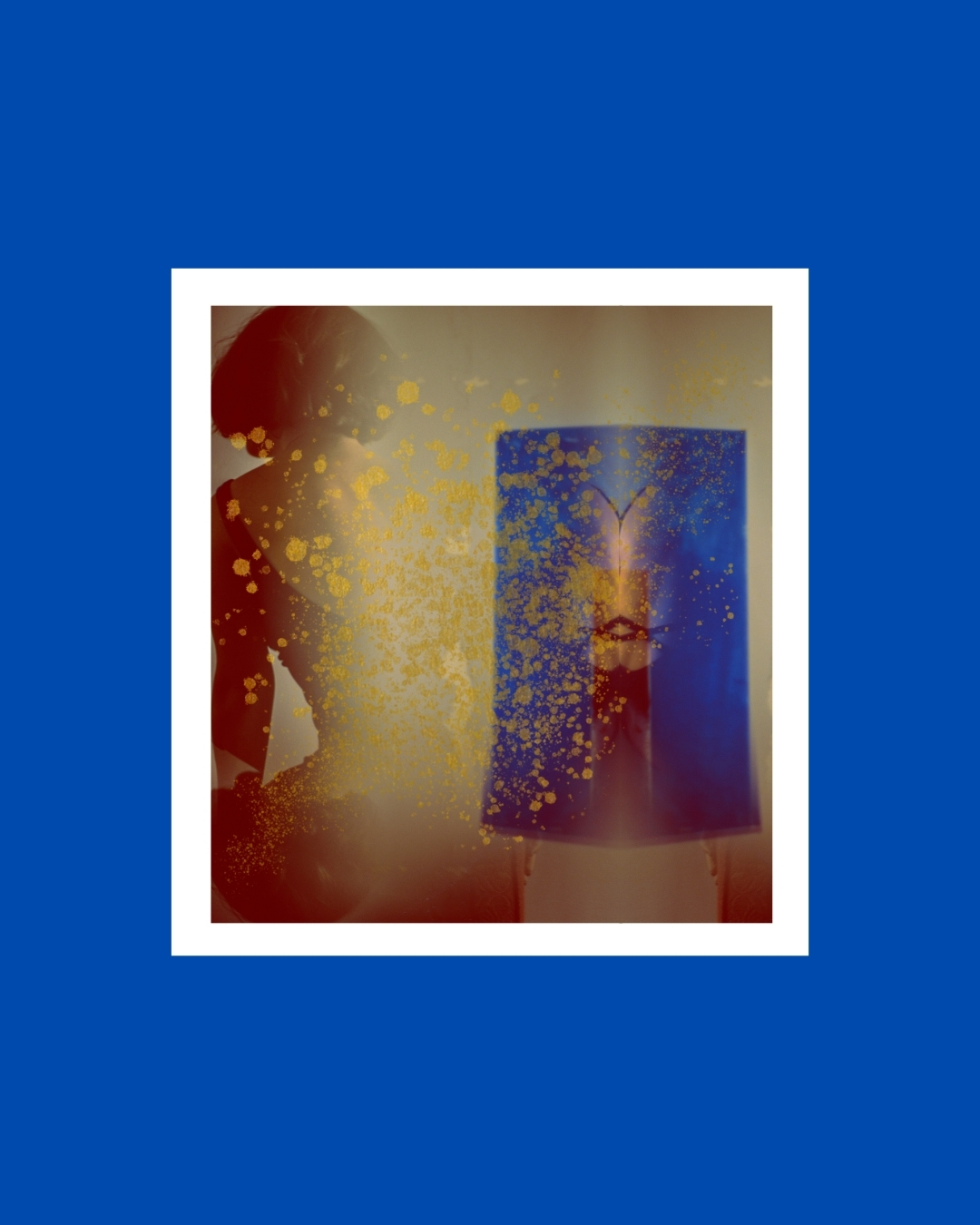A dark-haired figure indoors, partly obscured by blurred shapes and patches of colour.