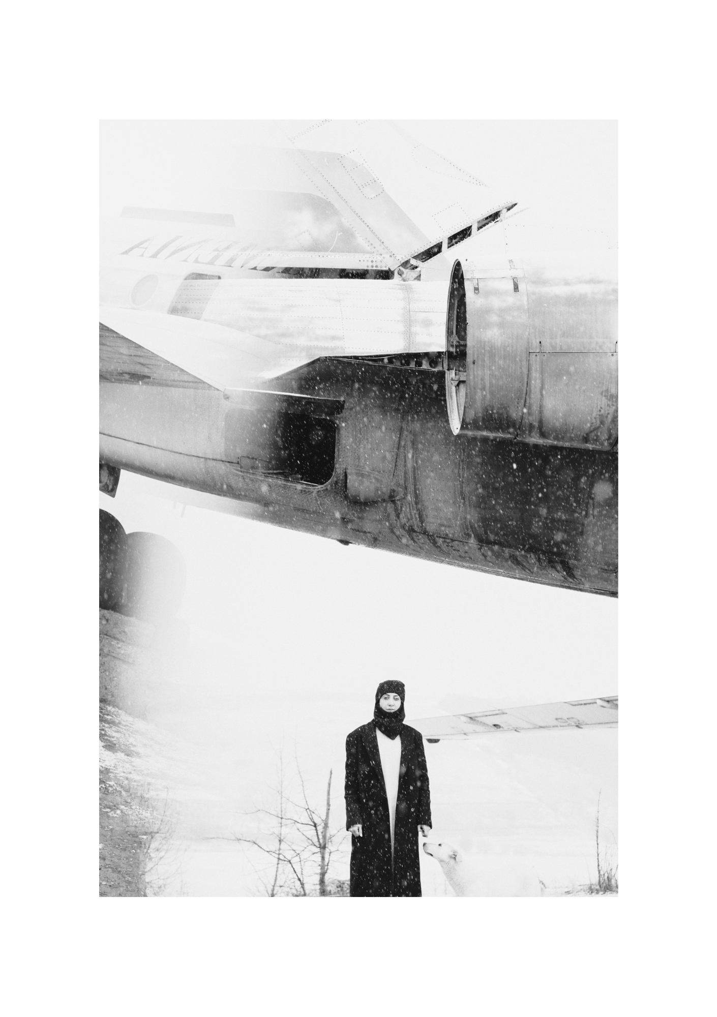A figure in dark clothing on snow-dusted ground, in black and white, by Lilit L Hovhanni.
