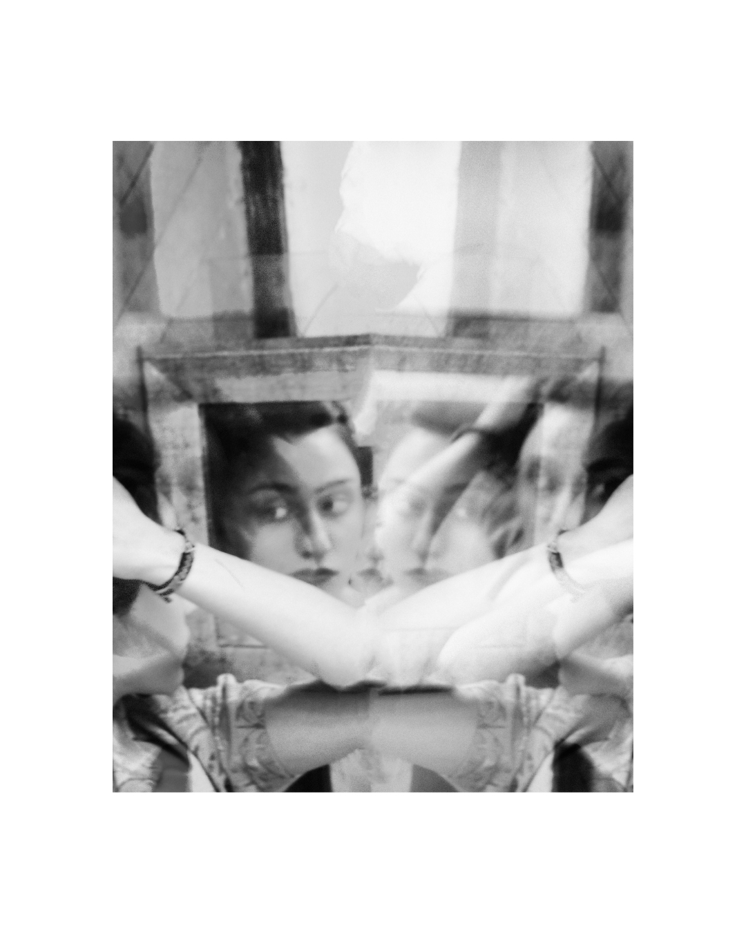 Light and shadow overlap a woman's face and shoulders in a black-and-white composition.