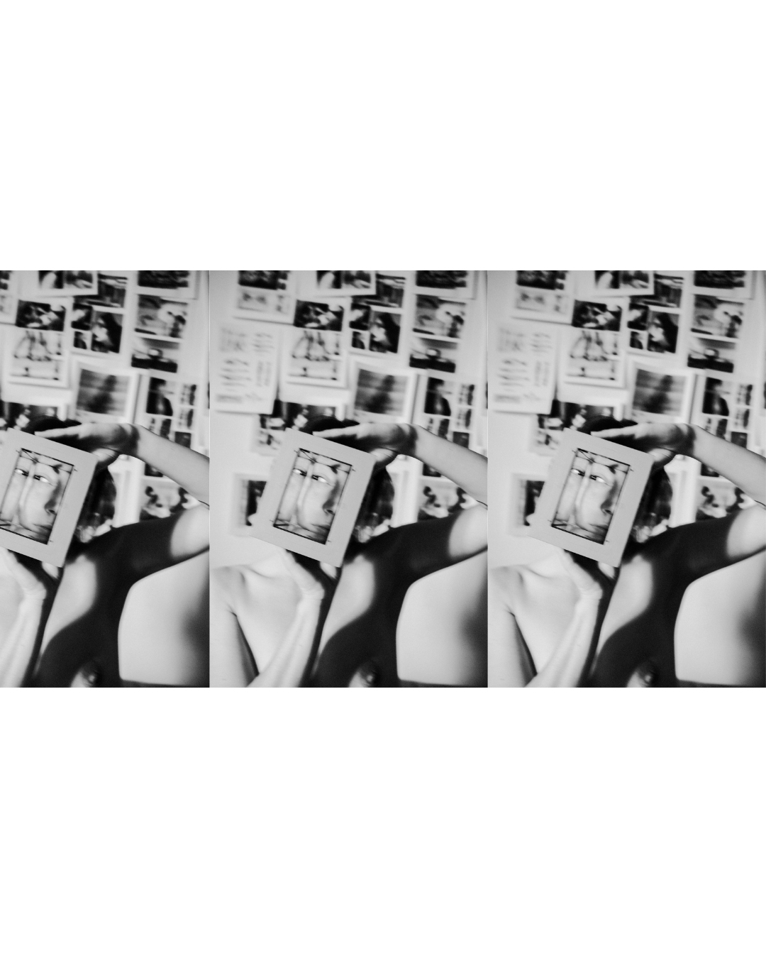 Black-and-white portrait of a figure with small printed images arranged on the wall behind them.