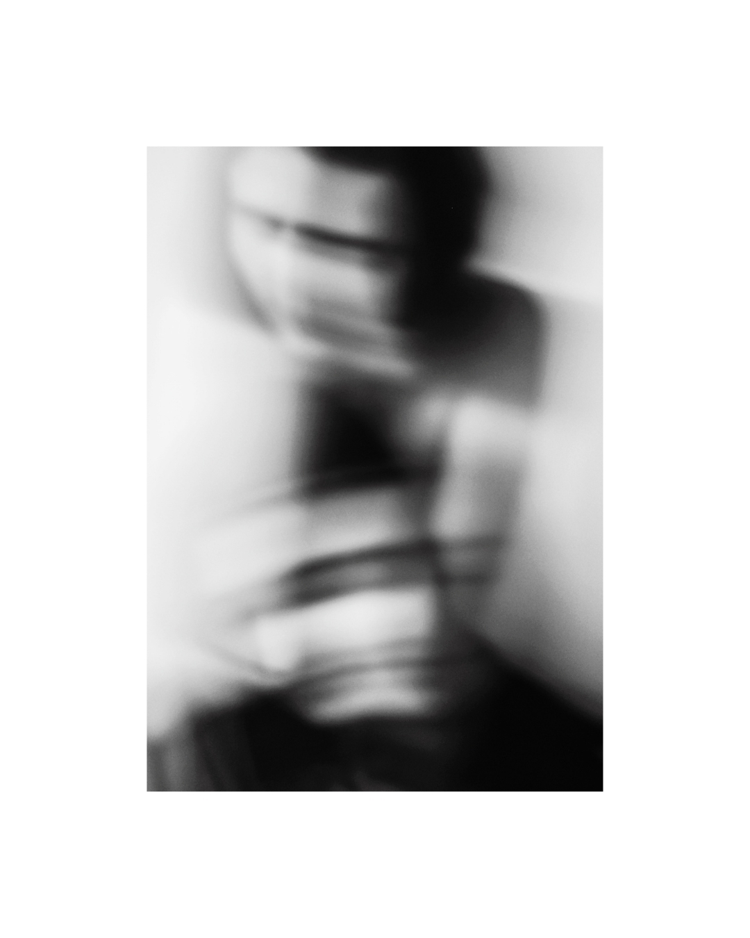 Dark hair contrasts with a pale backdrop in a tightly cropped monochrome view of women.