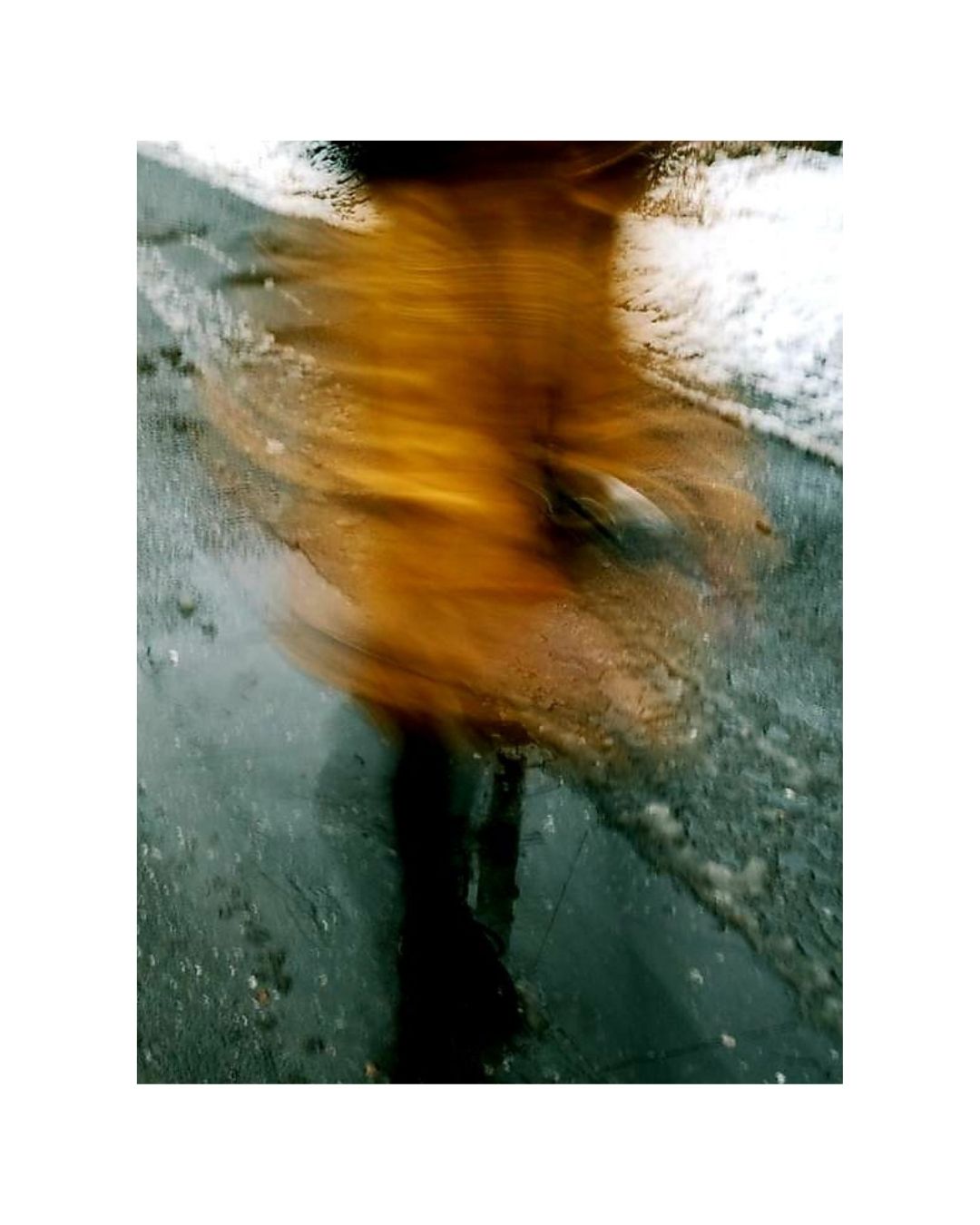 A person fills a vertical frame, with parts of the body cropped and a broad white border around the scene.
