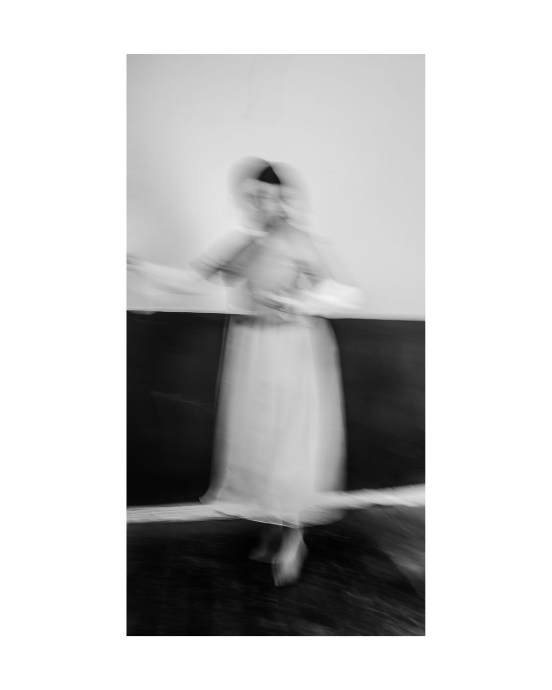 A person fills a vertical frame, with parts of the body cropped and a broad white border around the scene.