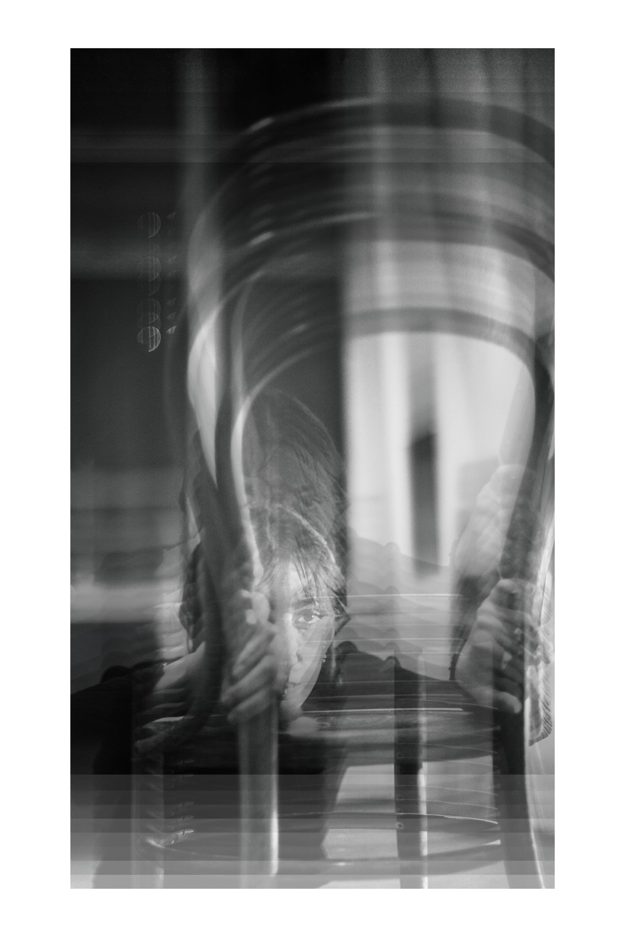 Strips of the same photograph stacked into one tall image, in black and white.