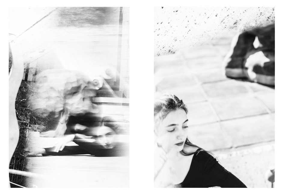 A reflection doubles a monument and the woman standing near it, in black and white.